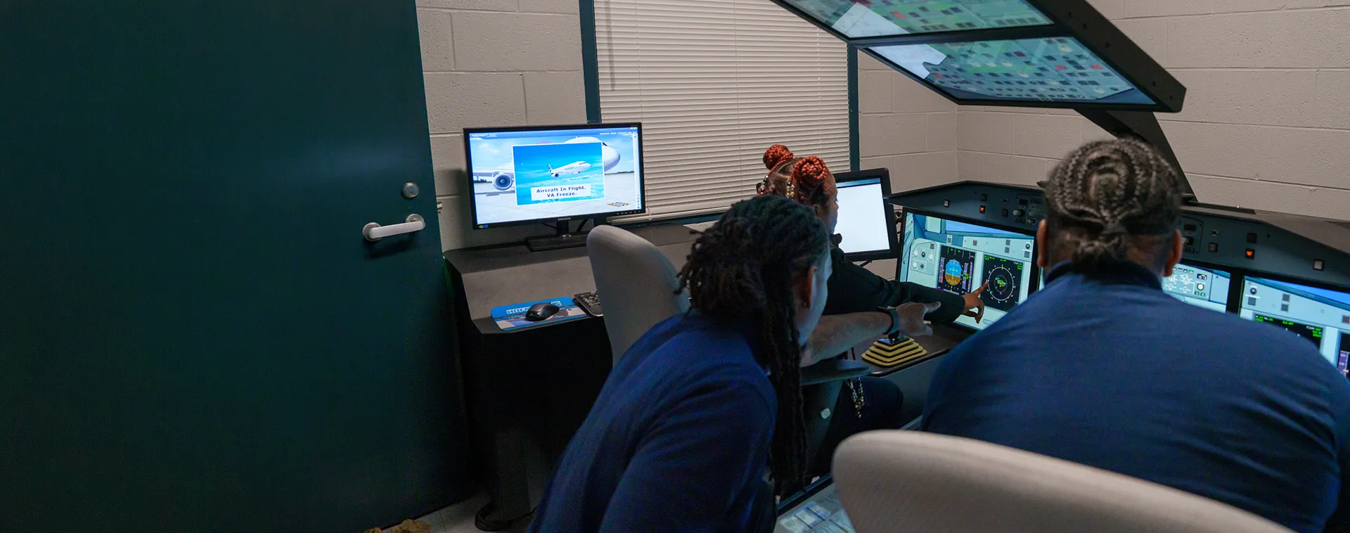 Students operate aircraft systems simulators and review instrument displays in an avionics training lab.